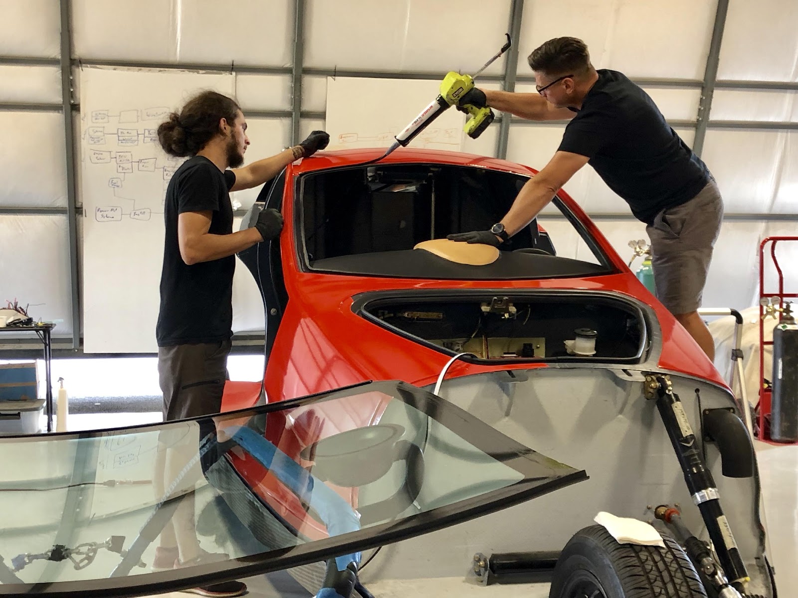 men applying glue around windshield of Switchblade