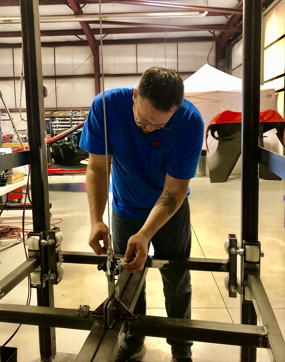 man standing by large metal framework used to do drop testing