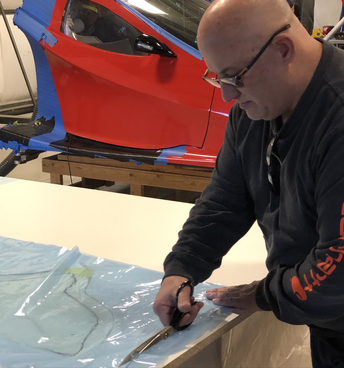 person cutting template for rear fire wall repair