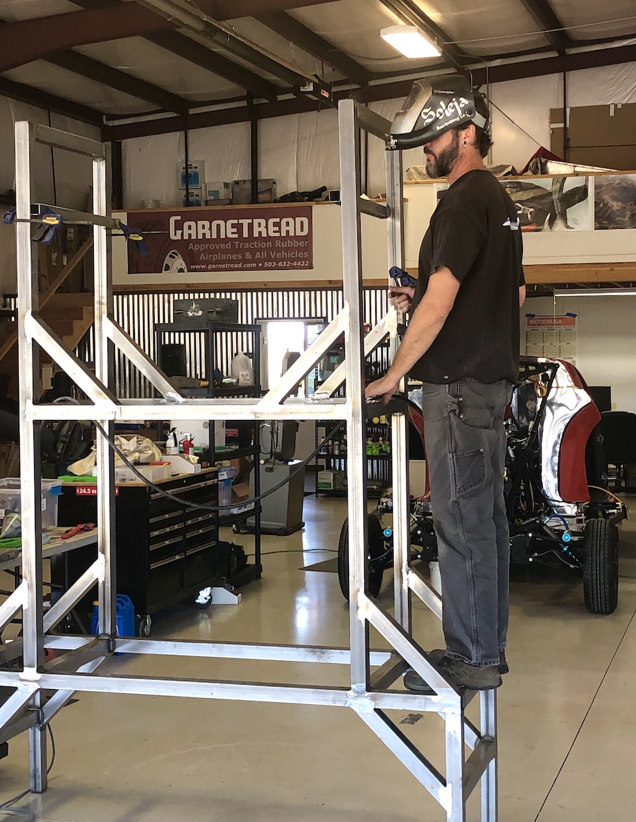 Joel building tail fixture on 9.23.21 person standing on metal framework building a tail fixture
