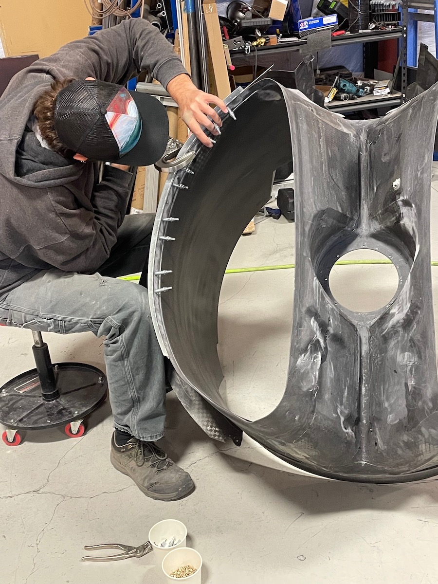 person inspecting rivits in a curved duct carbon fiber form
