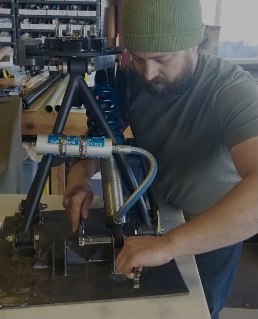 getting ready for new drop test on rear suspension 2.10.22 A person working on the rear suspension unit